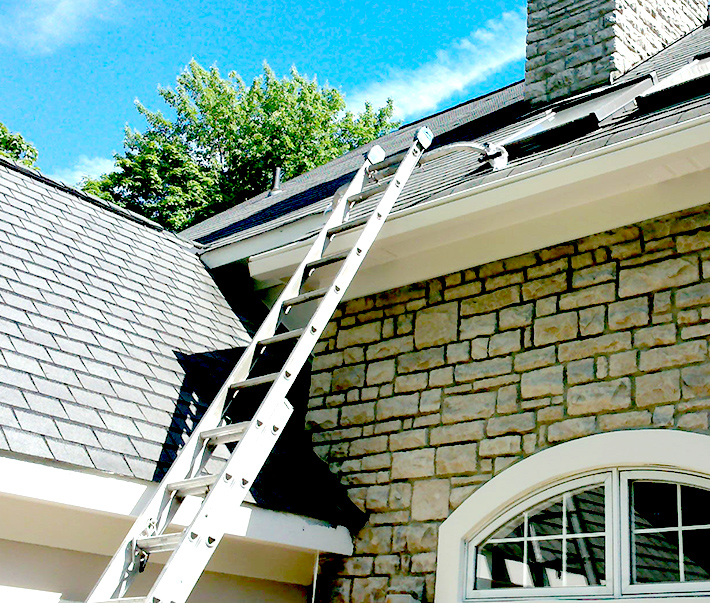 Residential house painters in Indianapolis setting up a ladder to paint gutters and exterior trim. 