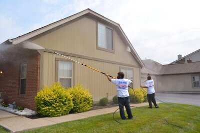 Two Color World exterior painters pressure washing the exteriors of a home